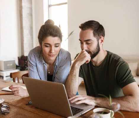 młoda para przed laptopem, przeglądająca oferty konsolidacji kredytów